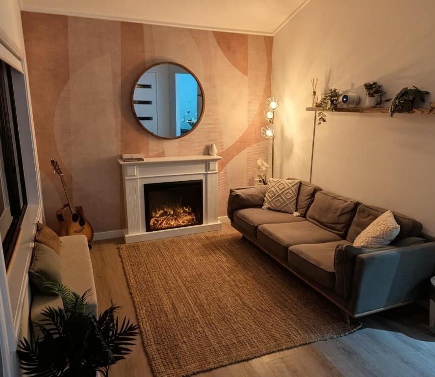 a living room with a couch and a fireplace at Mollymook Den Coastal Retreat - Walk to Beach & Town in Mollymook