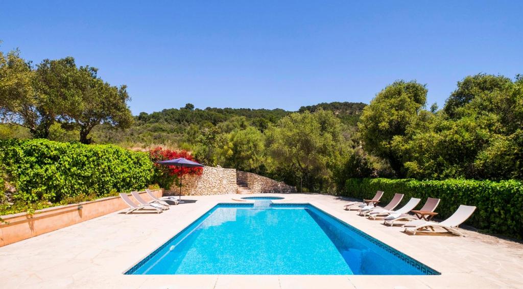 a swimming pool with lounge chairs and a swimming pool at Son Reus in Felanitx