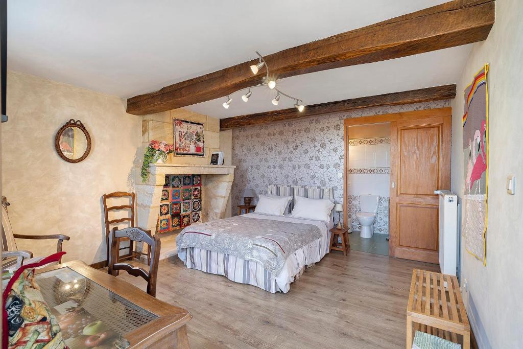 a bedroom with a bed and a table in it at Chambre d'Hotes La Roseraie in Saint-Émilion