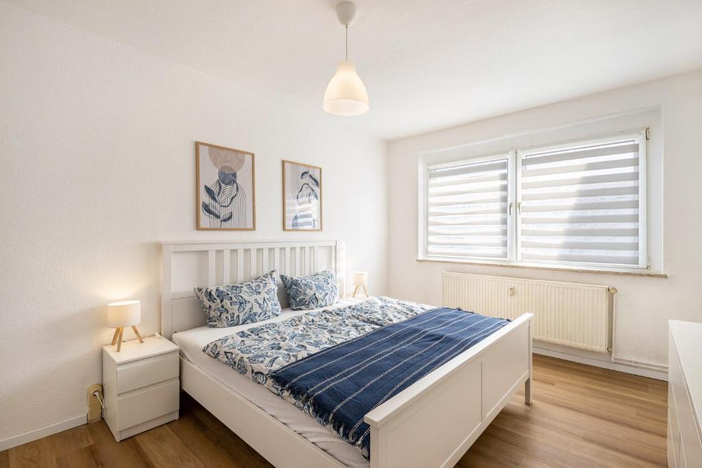 a white bedroom with a bed and a window at Ferienwohnung Mücheln in Mücheln