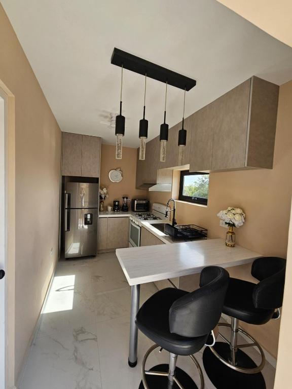 a kitchen with a table and two black chairs at Happy stay297 in Paradera