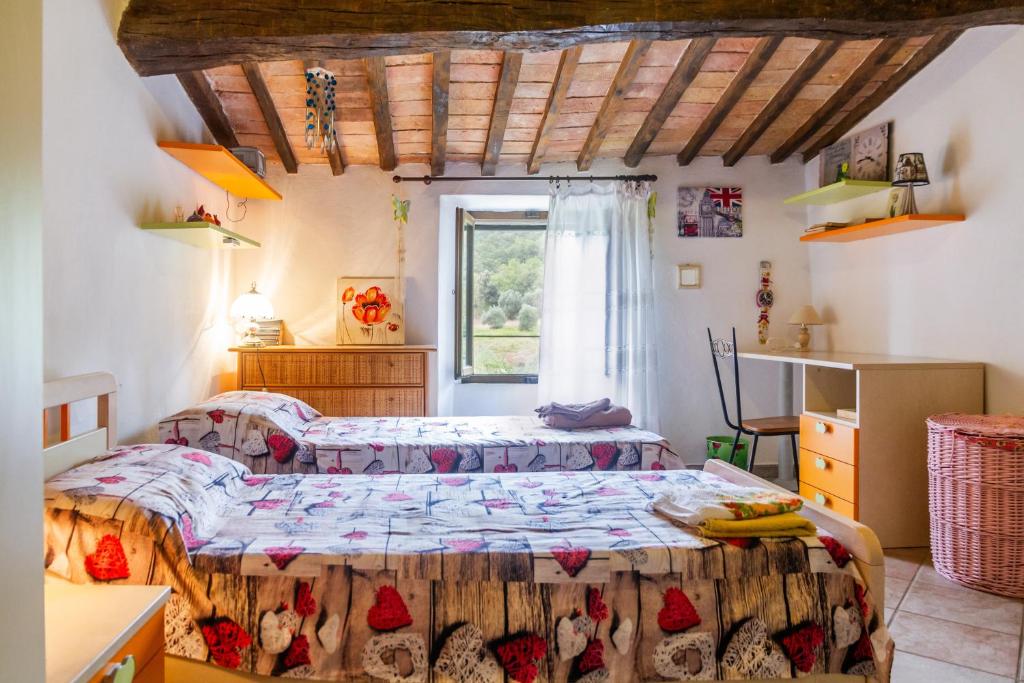 a bedroom with two beds and a window at Querciagrossa da Dora in Roccastrada