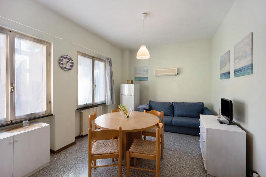 a living room with a table and a blue couch at Appartamento Orizzonte 3 A in Diano Marina