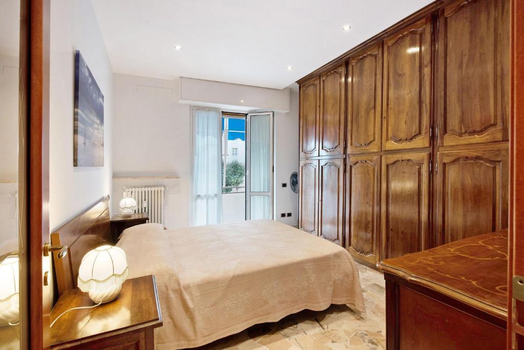 a bedroom with a bed and wooden cabinets at Le Vele in Albissola Marina