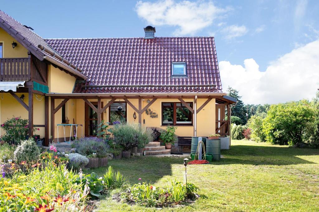a yellow house with a red roof at Ferienhaus Engert mit Holzofensauna in Althüttendorf