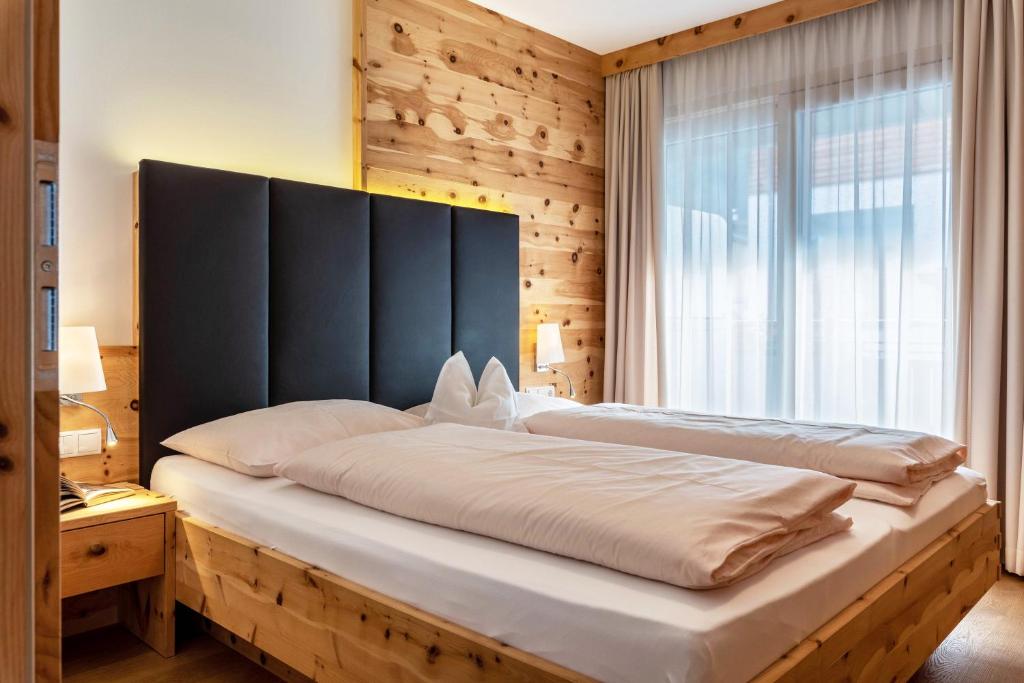 a bedroom with a large bed with a large window at Apartments Marialisa Superior Orchi in Chiusa