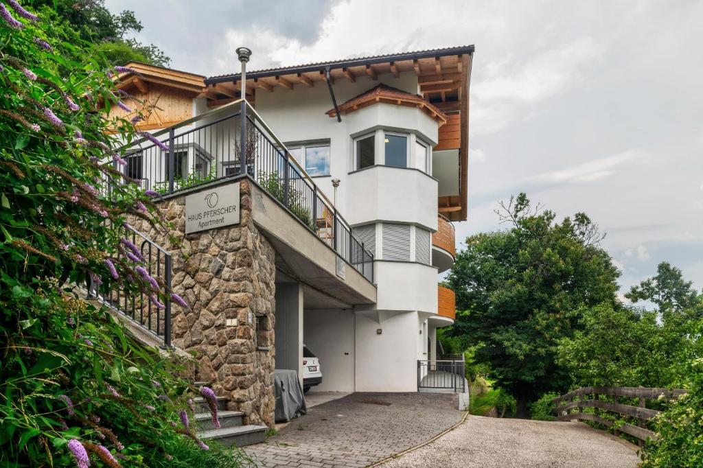 a white building with a balcony on the side at Haus Pferscher in Barbiano