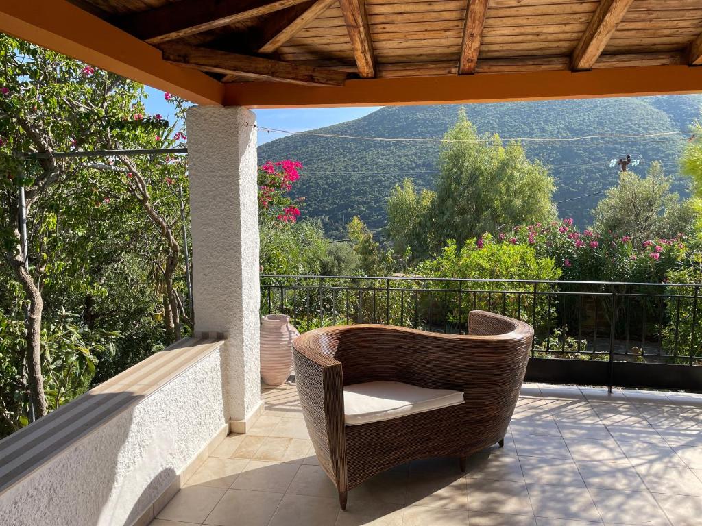 a wicker chair sitting on a balcony with a view at Divas Gartenhaus in Vasilítsion
