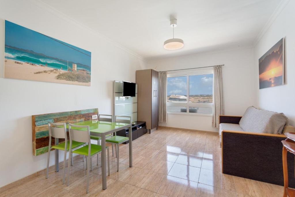 a living room with a glass table and a couch at apto luminoso lagos del cotillo in La Oliva