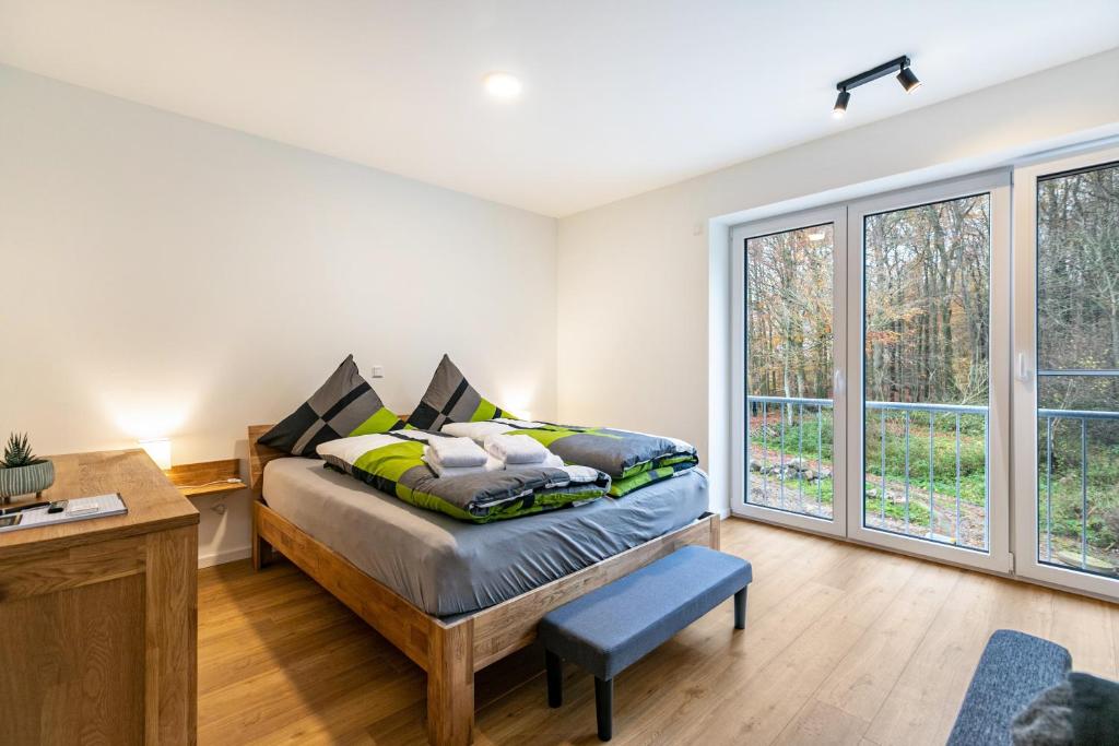 a bedroom with a bed and a desk and windows at Grötacker Wohnung 6 in Husby
