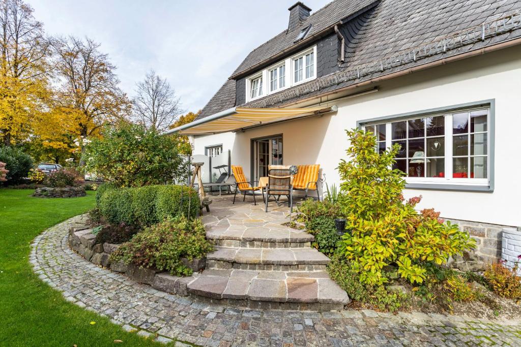 a patio with chairs and a table in front of a house at Ferienwohnung Sommersonne in Warstein