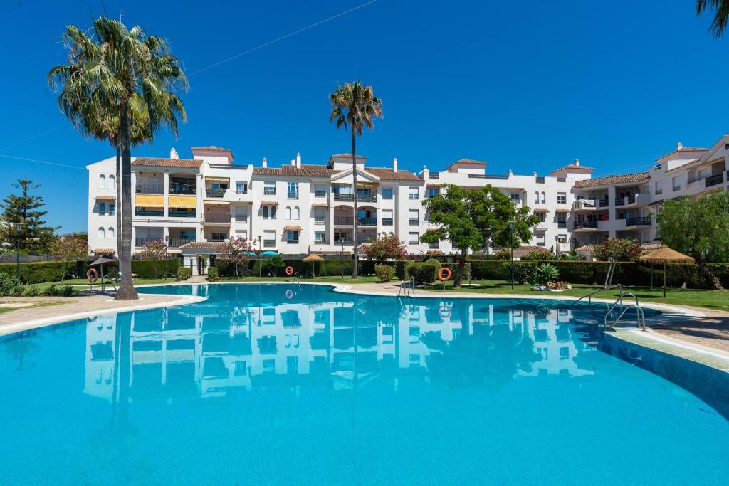 a large swimming pool in front of a building at Marbella Beach San Pedro in Marbella