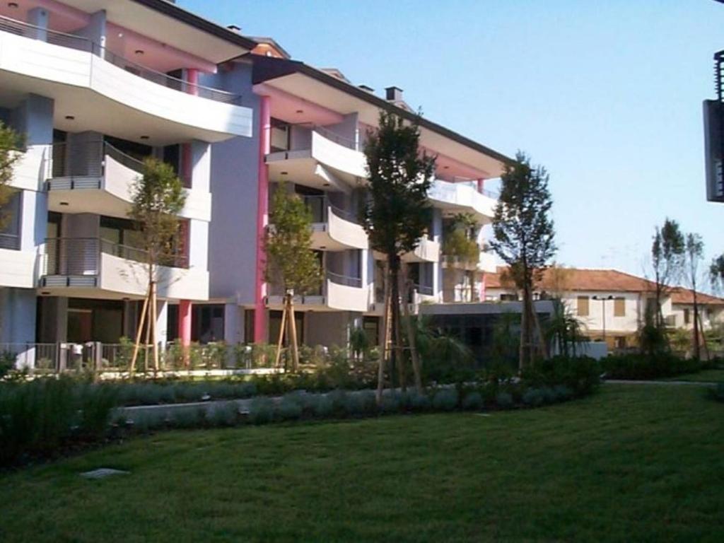 a large apartment building with trees in front of it at Appartamento Costa Azzurra in Grado