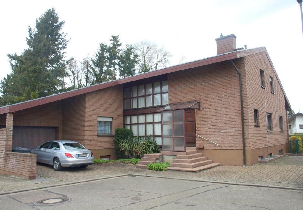 a brick house with a car parked in front of it at Ferienhaus Mengelberg in Roschbach