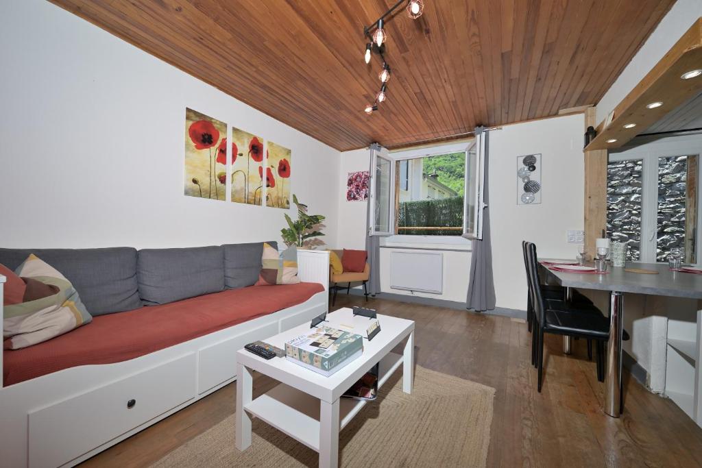 a living room with a couch and a table at Le Gite des 3000 avec Spa in Auzat