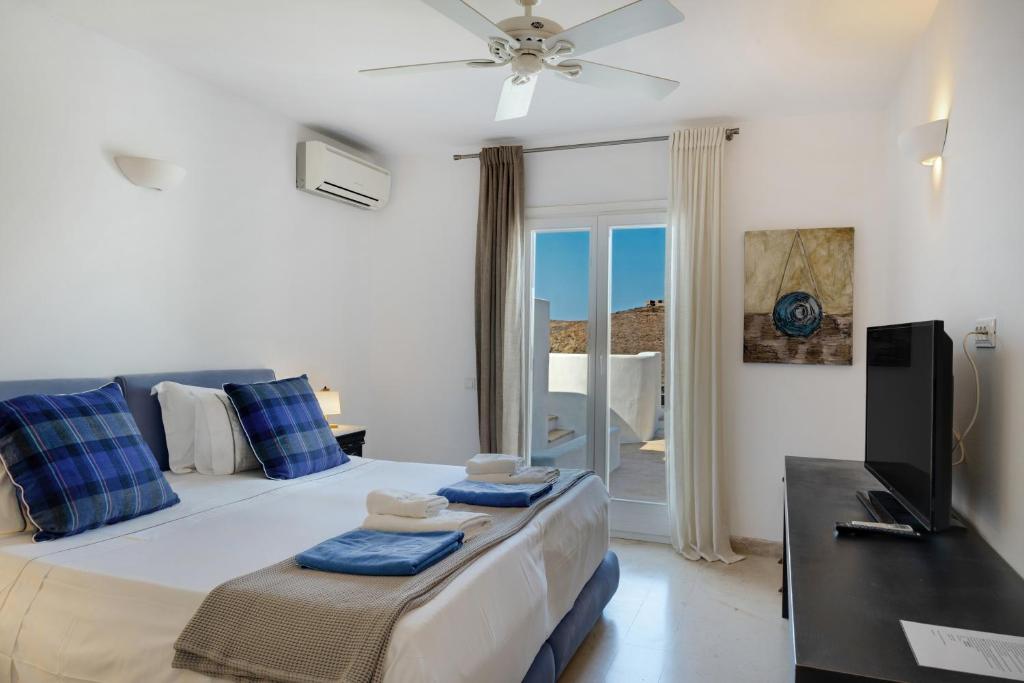 a bedroom with a large bed and a television at Blueros - Main Villa in Megas Gialos - Nites