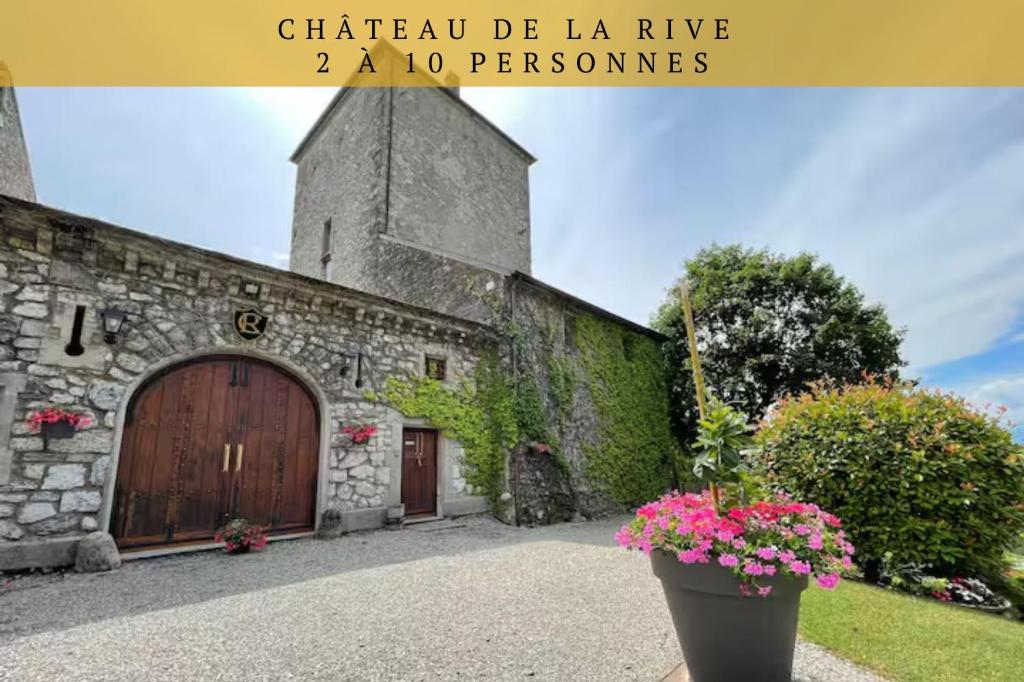 a building with a door and flowers in front of it at Château De La Rive in Cruet
