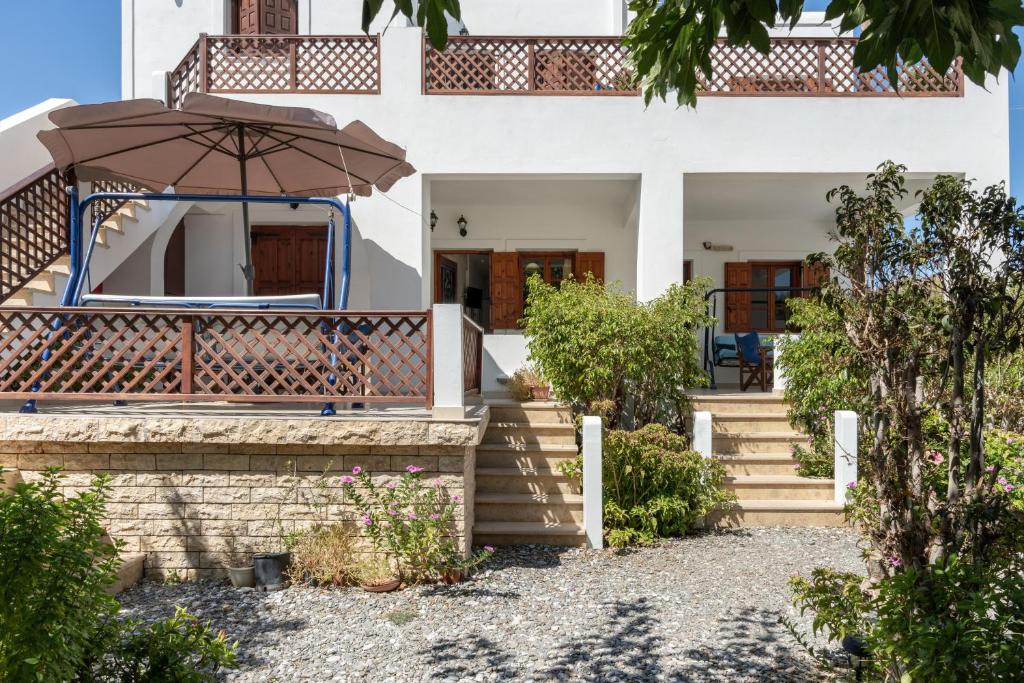 a house with a staircase and an umbrella at Studios Asterias 3 in Astypalaia