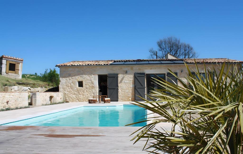 a villa with a swimming pool in front of a house at Ferme De Berteillé in Castérat-Bouzet