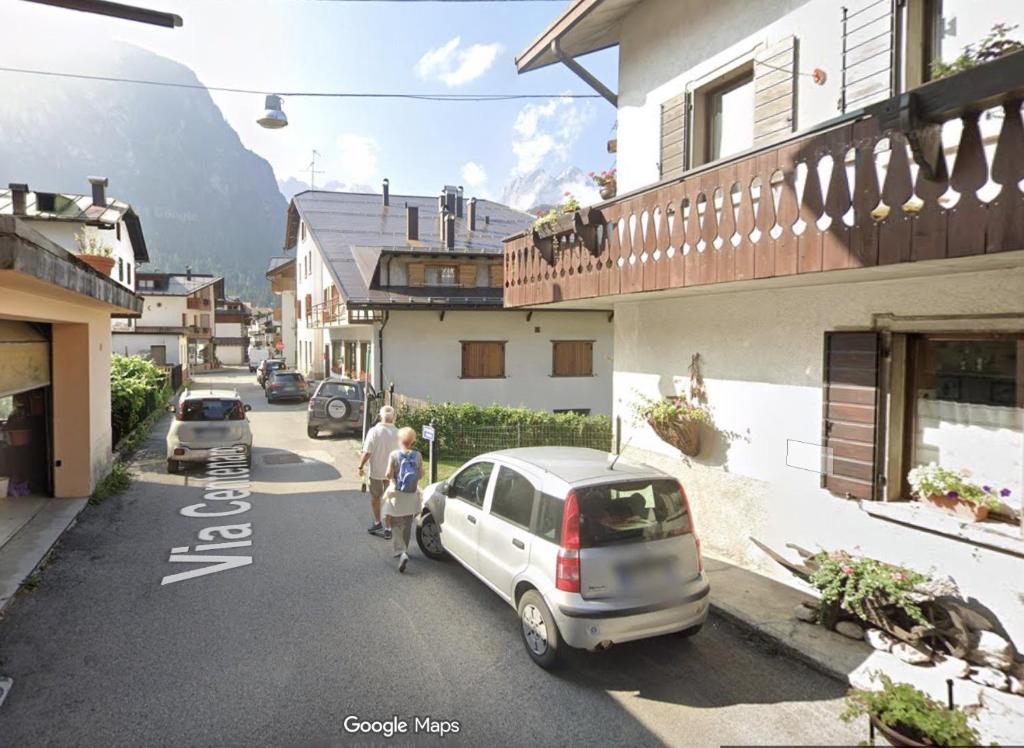 a couple of people walking down a street with a car at Casa D'Ambros - Cadore in Santo Stefano di Cadore