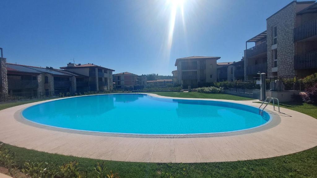 a large blue swimming pool in a yard at New Casa Tiberio in Lazise