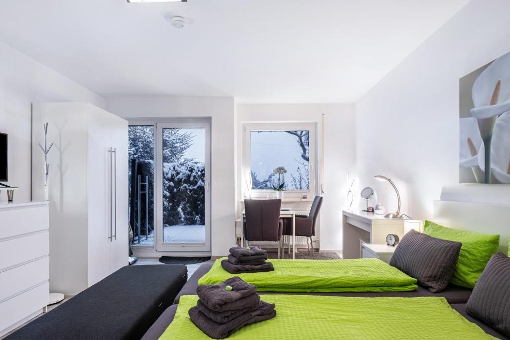 two beds in a room with green sheets at Schwarzwaldblick C App 2 mit Pool in Schönwald