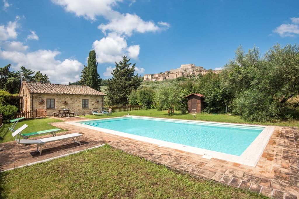 a swimming pool in a yard with a house at Villa Agriturismo Il Pratone in Castiglione dʼOrcia