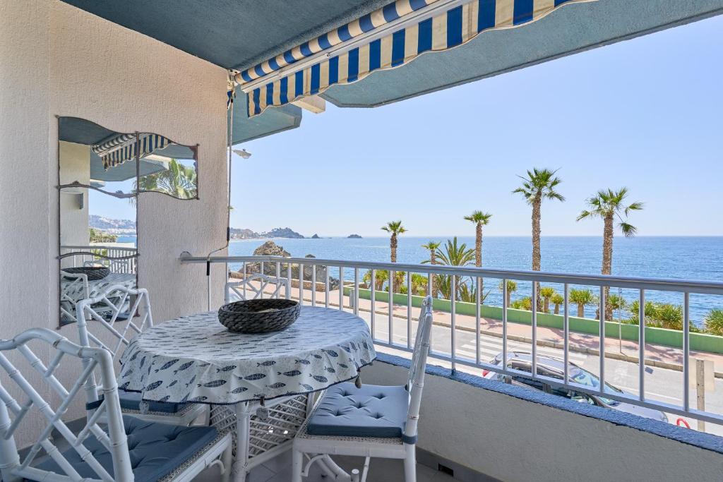 a table and chairs on a balcony with a view of the ocean at Brisa Marina in Almuñécar