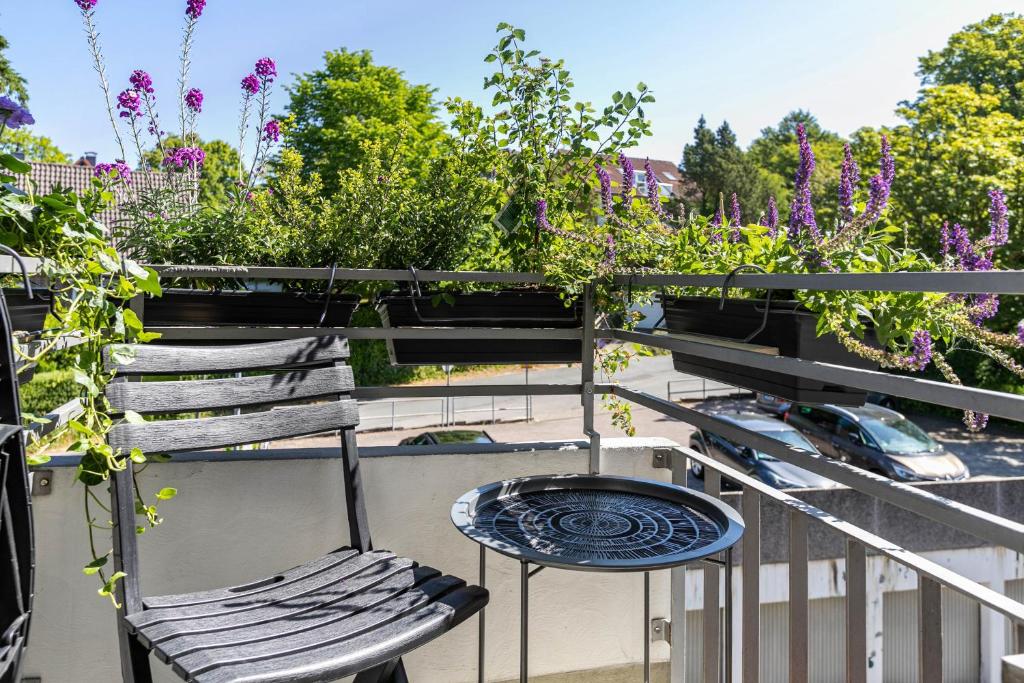 a chair and a table on a balcony with flowers at Ferienwohnung mit Badestrand in Glücksburg