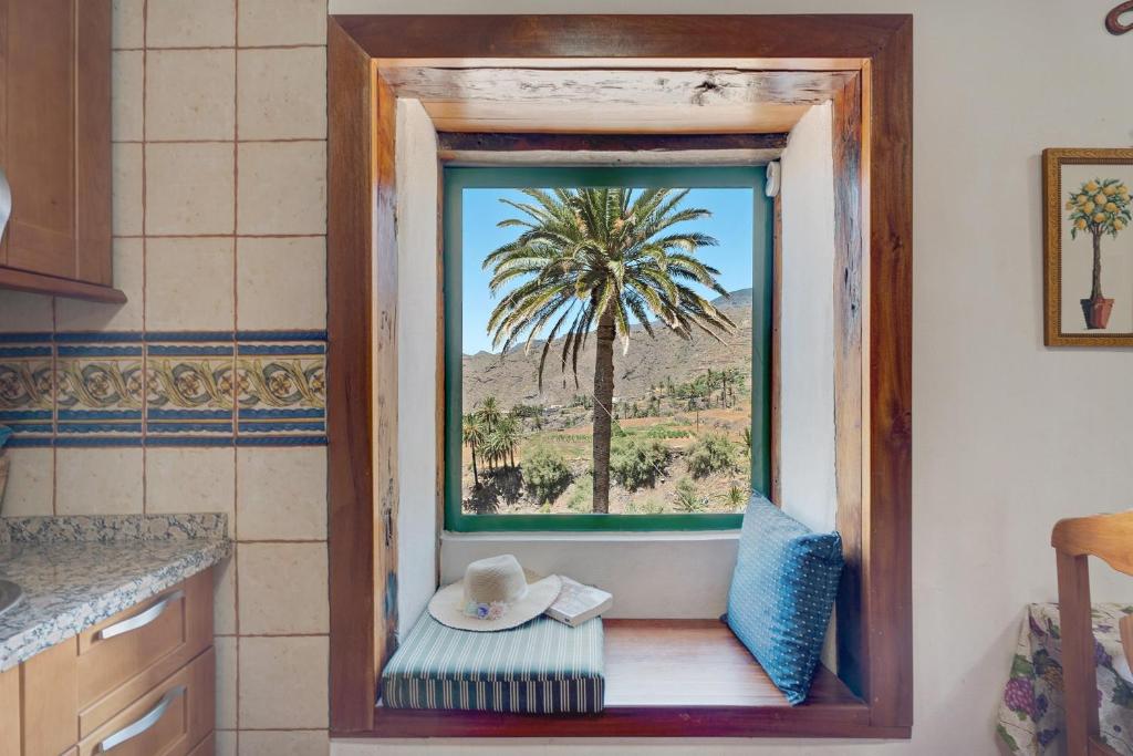 a kitchen with a window with a palm tree at Rosa del Negro in Alojera