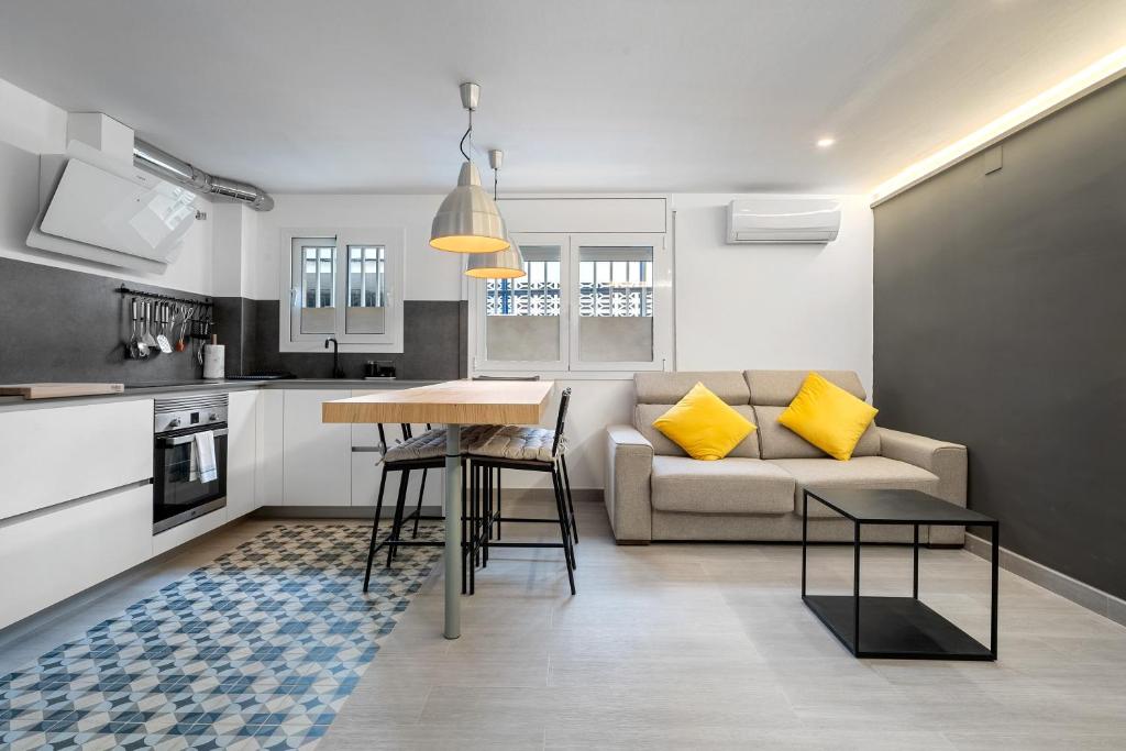 a kitchen and living room with a table and a couch at Kaixo in Calafell