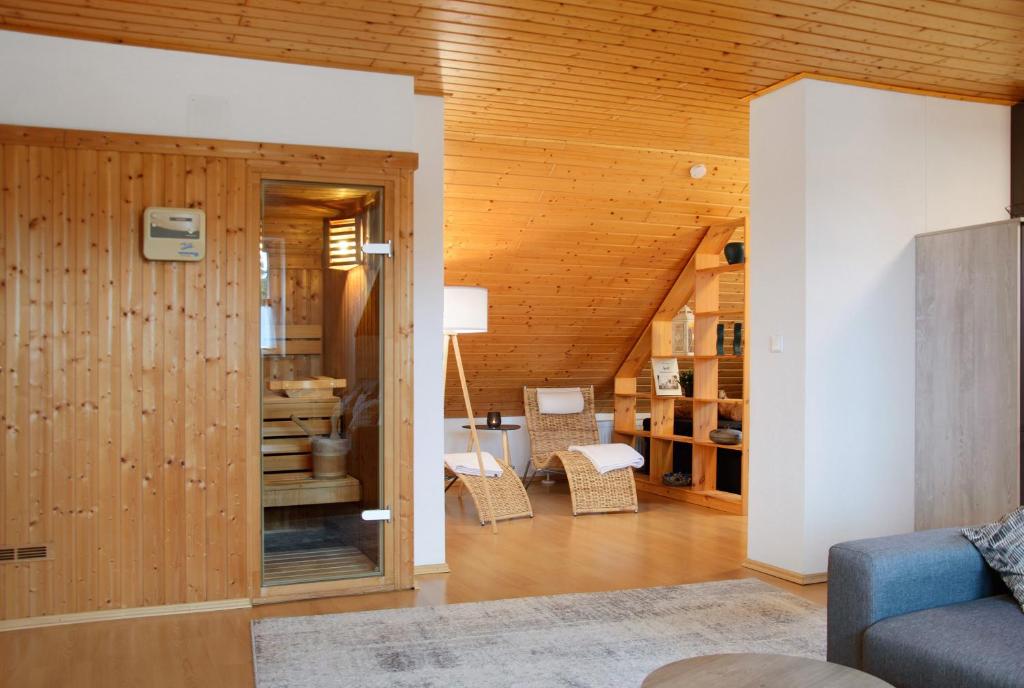 a living room with wooden walls and a room with a couch at Wohnung Karin in Spalt