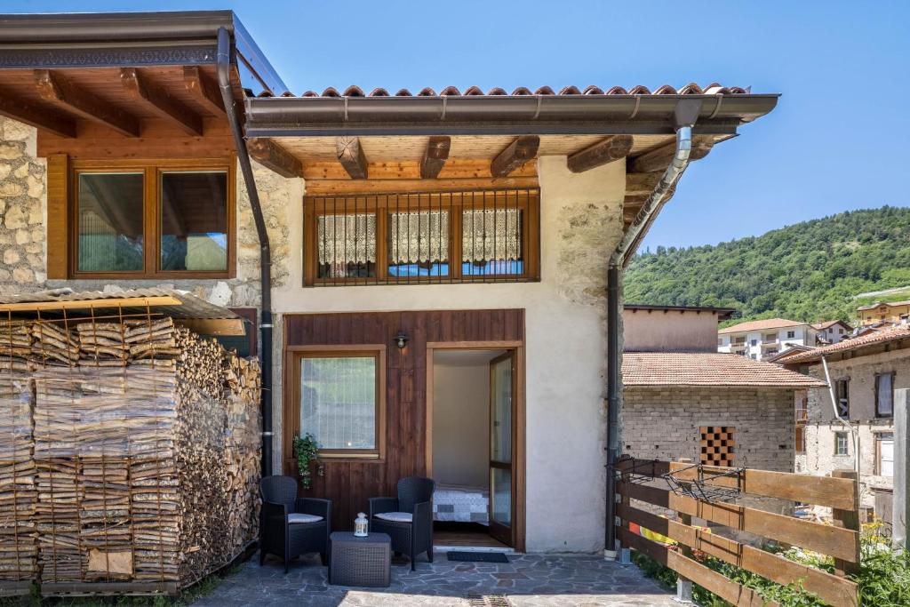 a house with a wooden door in a village at Agritur piazera con terrazzo in Ronzo Chienis