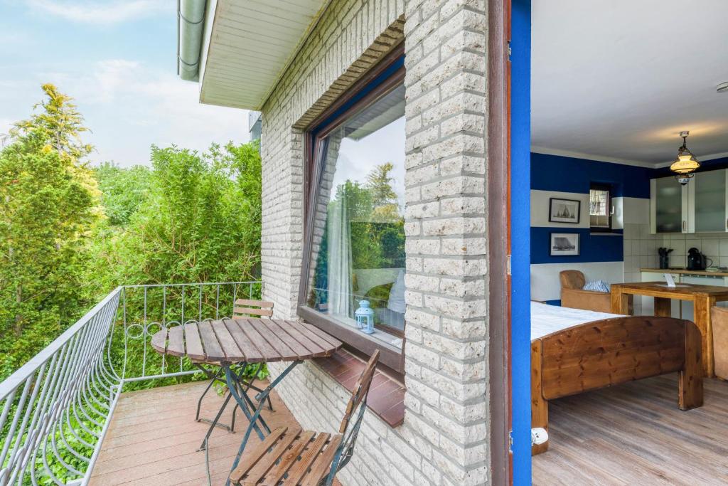 a room with a balcony with a table and a bed at Landhaus Ostseeblick Fewo 5 - in Kronsgaard