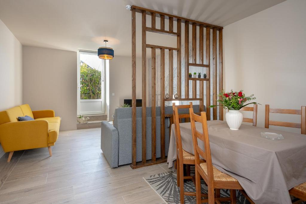 a living room with a dining room table and a couch at Gite La Maison Du Soyeux Ga in Les Abrets en Dauphine
