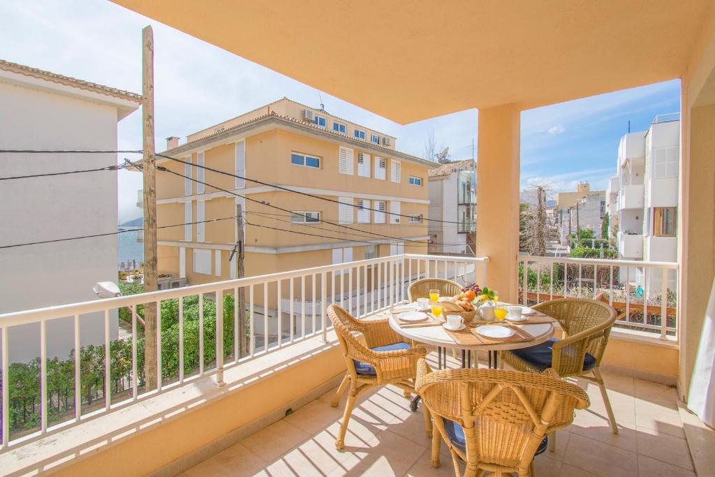 a patio with a table and chairs on a balcony at Talaia 1a in Port de Pollensa