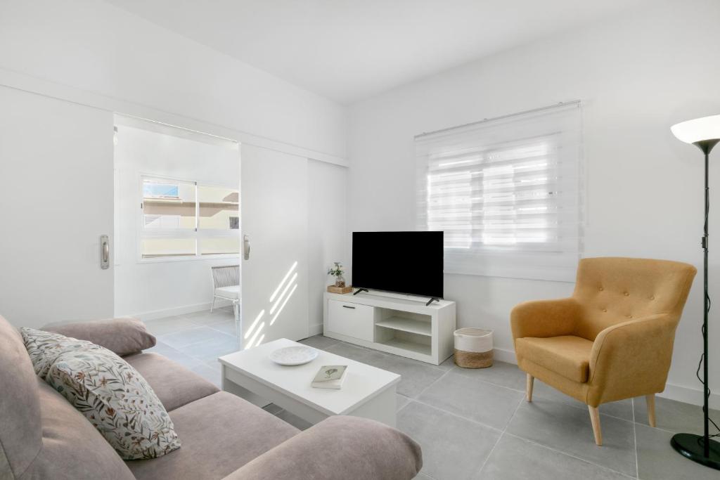 a living room with a couch and a chair and a tv at El Ramonal Home in Candelaria