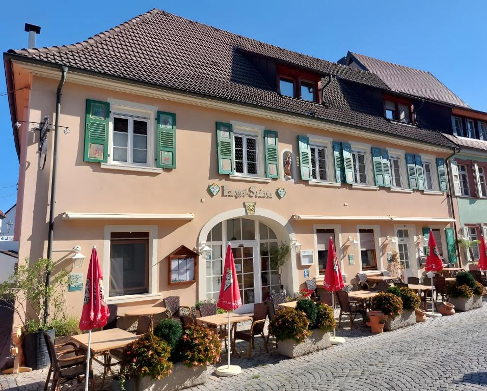 a building with tables and umbrellas in front of it at Apartment Schwär in Endingen