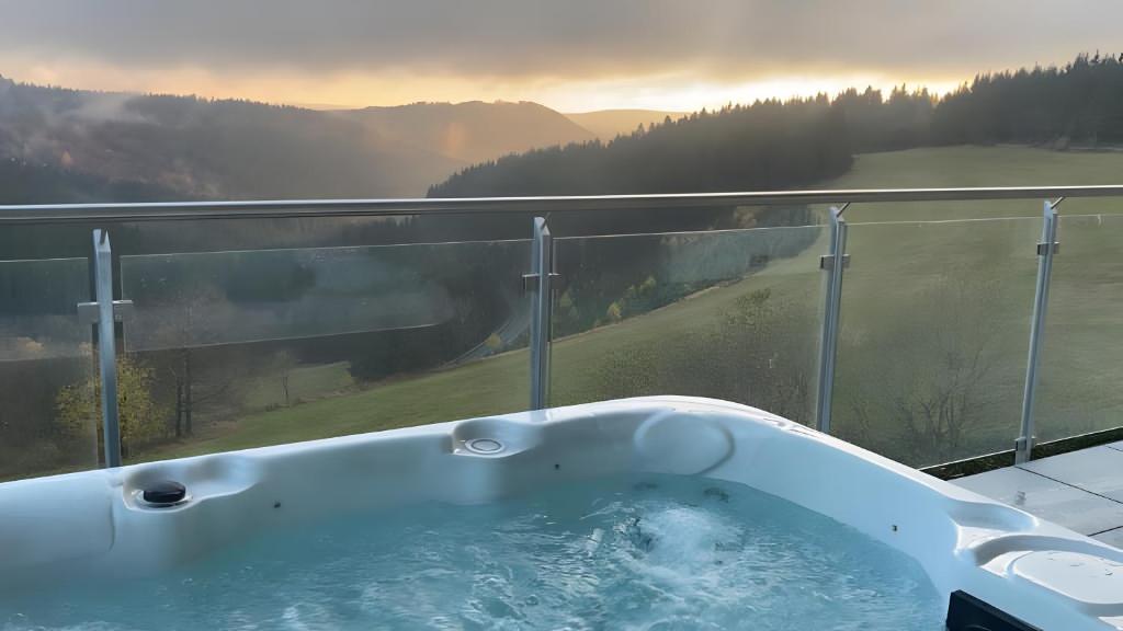 a bath tub on a balcony with a view at Wellness Appartement Winterberg E2 in Winterberg