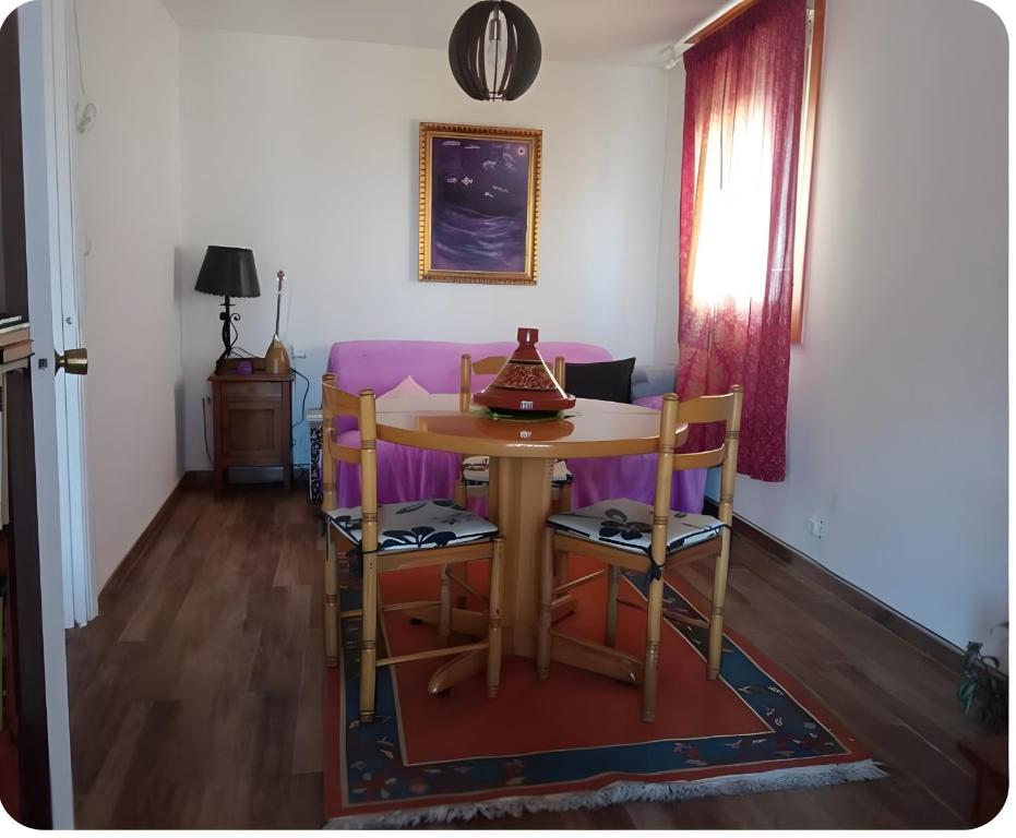 a dining room with a table and a purple couch at Villa Lukita in Cangas de Morrazo