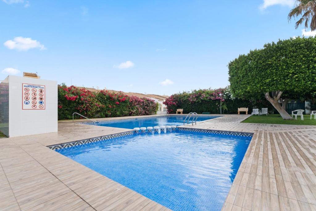 a swimming pool with blue water in a yard at Casa Max in Gran Alacant