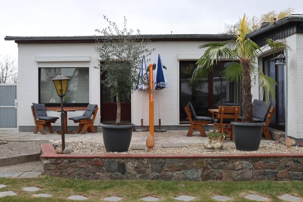 a house with a patio with chairs and an umbrella at Haus Meereswelle in Büsum