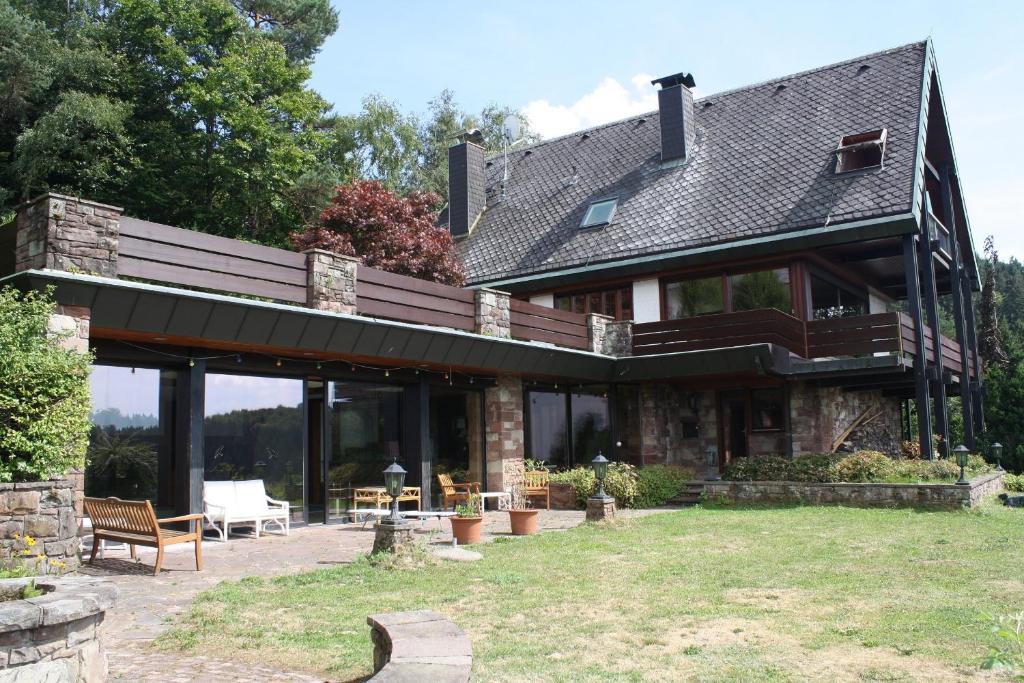 a large house with a roof with a patio at Haus Talblick Sasbachwalden in Sasbachwalden