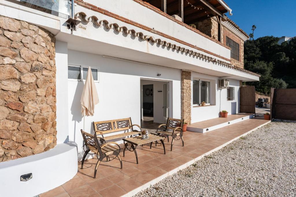a patio of a house with chairs and a table at Apartamento Timón in Mijas