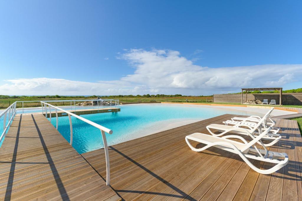 a deck with lounge chairs next to a swimming pool at Paraiso da Serva - Flor do Rosto 2 in Odemira