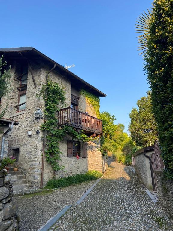 a stone building with a balcony on a cobblestone street at Cascina Taronico in Bellagio