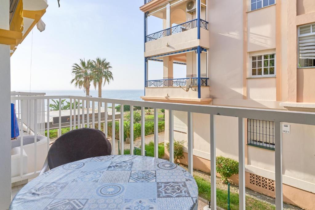 a balcony with a table and a view of the ocean at Ferienwohnung Peñoncillo in Torrox
