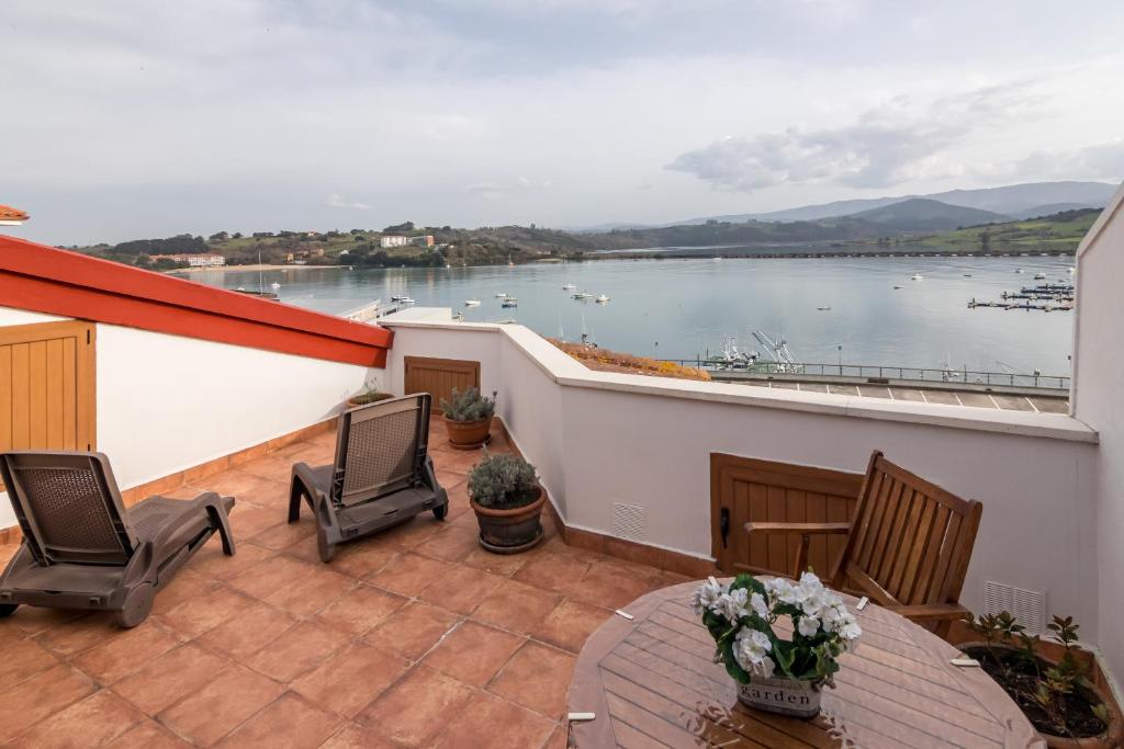 a balcony with chairs and a view of the water at Estudio La Barquera in San Vicente de la Barquera