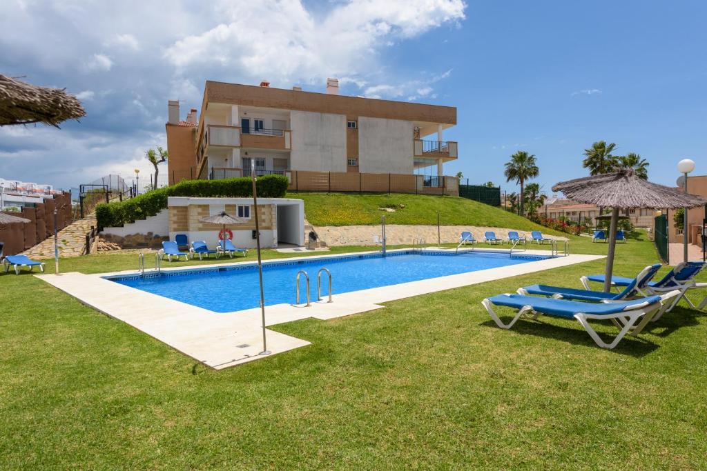 a villa with a swimming pool in front of a building at Casa Patagonia in Manilva