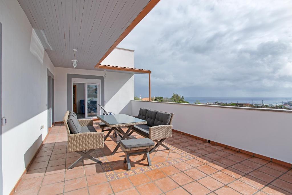 a patio with a table and chairs on a balcony at Los Adejo vacacional in Moya